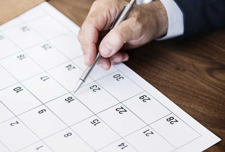 mano di un uomo che scrive su un calendario