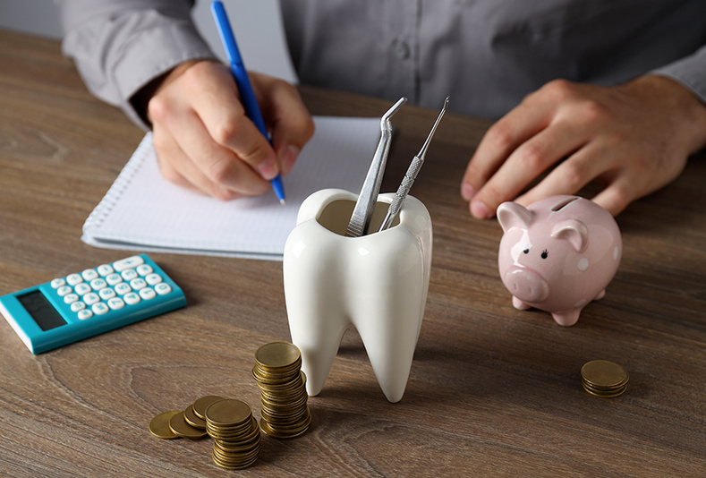 Scrivania con portapenne a forma di dente, calcolatrice e risparmi con salvadanaio