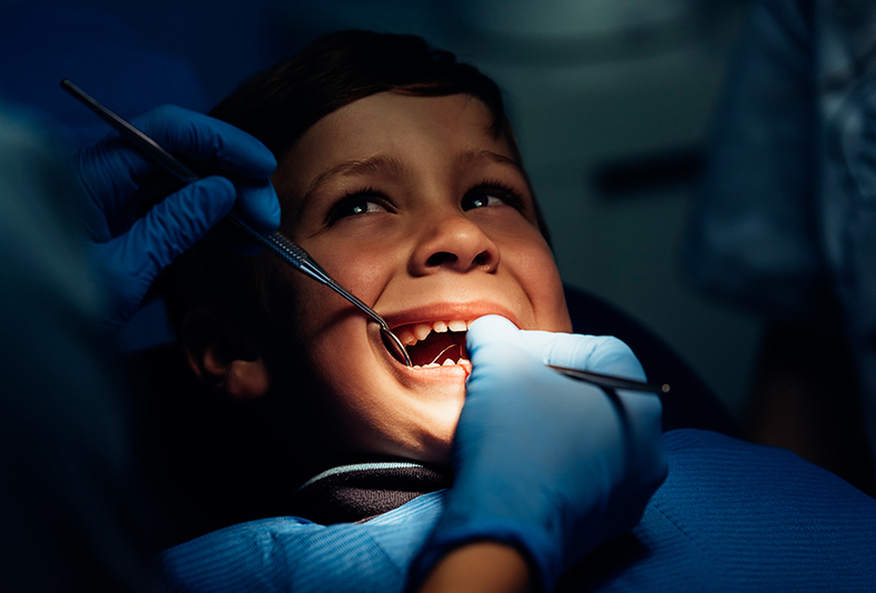 Bambino dal dentista a cui viene effettuata l'estrazione di denti