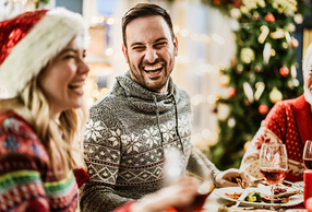 Uomo a tavola durante le festività natalizie che sorride