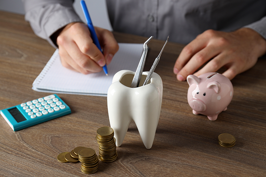 Scrivania con portapenne a forma di dente, calcolatrice e risparmi con salvadanaio