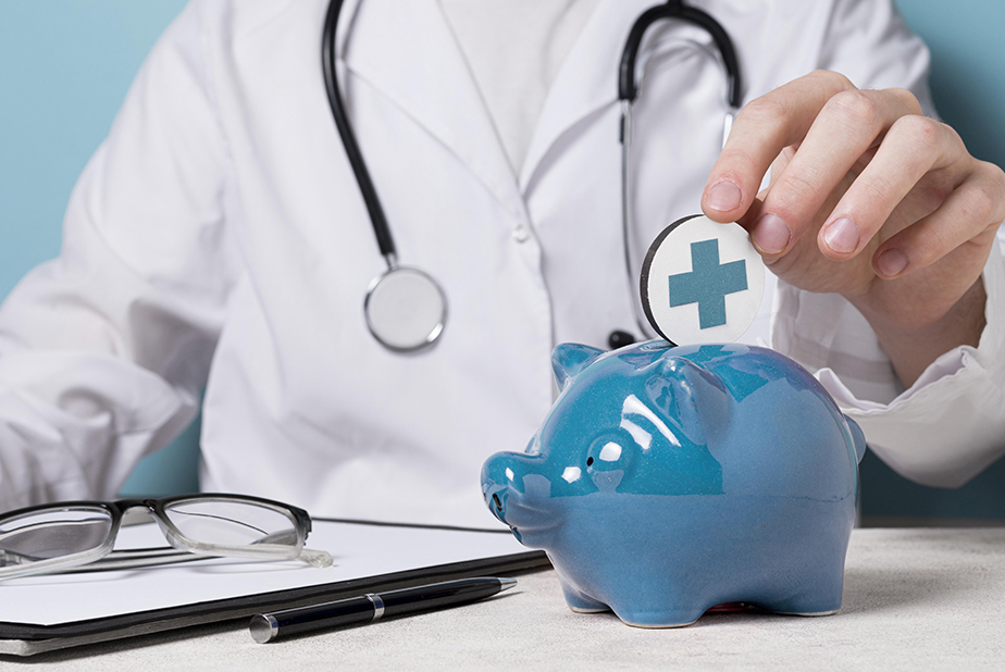 Mano di medico con salvadanaio