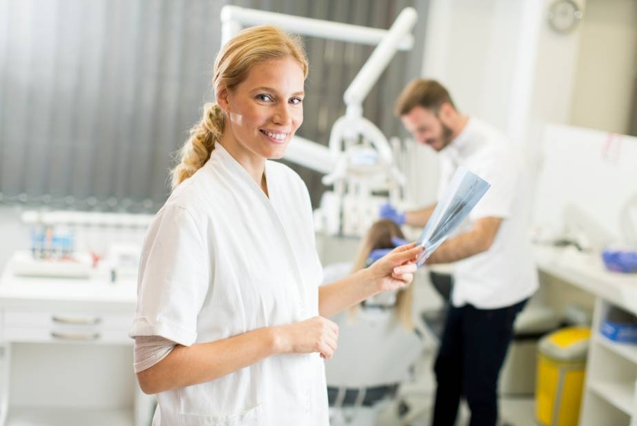 Aso in studio odontoiatrico con medico alle spalle