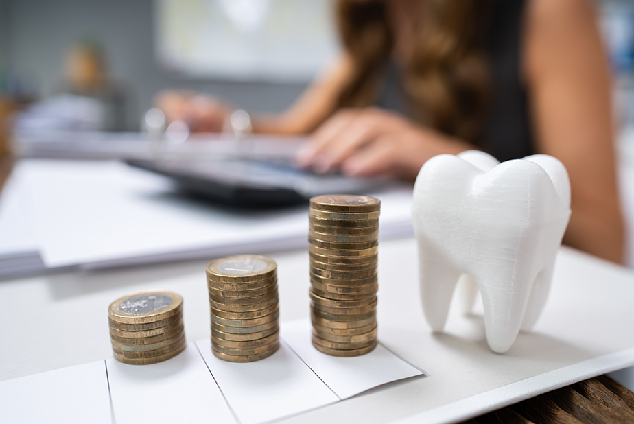 Modellino a forma di dente e monete impilate