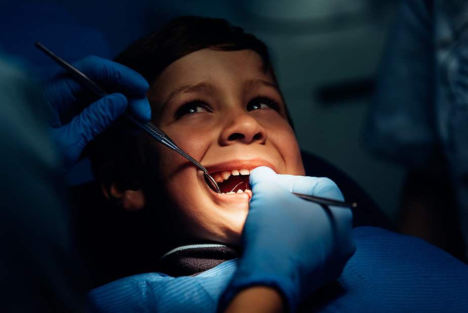 Bambino dal dentista a cui viene effettuata l'estrazione di denti